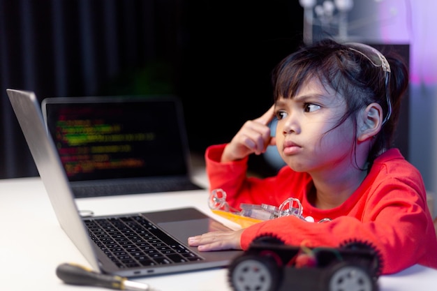 Los estudiantes de Asia aprenden en casa codificando autos robot y cables de tableros electrónicos en STEM STEAM matemáticas ingeniería ciencia tecnología código de computadora en robótica para niños concepto