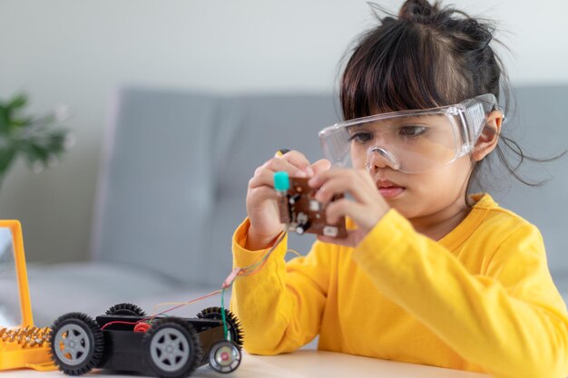 Los estudiantes de Asia aprenden en casa a codificar automóviles robot y cables de placa electrónica en STEM, STEAM, código informático de tecnología de ciencia de ingeniería matemática en robótica para el concepto de niños.