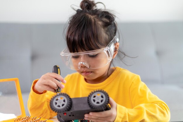 Los estudiantes de Asia aprenden en casa a codificar automóviles robot y cables de placa electrónica en STEM, STEAM, código informático de tecnología de ciencia de ingeniería matemática en robótica para el concepto de niños.