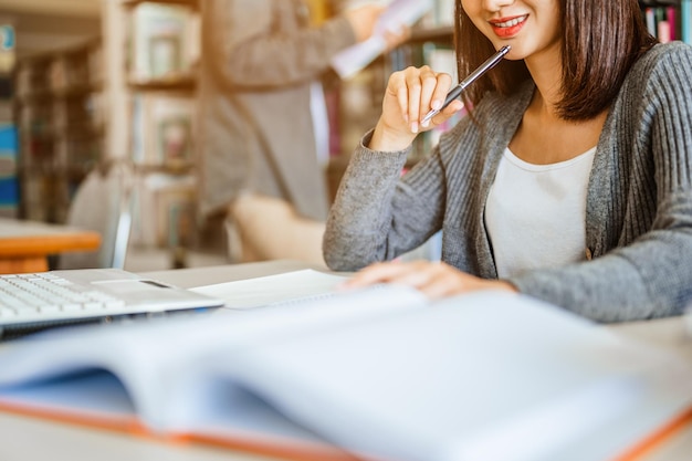 Foto las estudiantes asiáticas están leyendo y discutiendo sobre la preparación del examen, pensando en las pruebas de preguntas