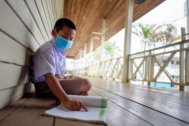 Estudiantes asiáticos de escuela primaria con máscara médica para prevenir el coronavirus