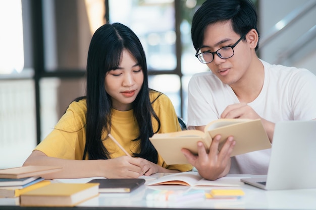 Estudiantes asiáticos están leyendo libros y estudiando Tutoría juntos