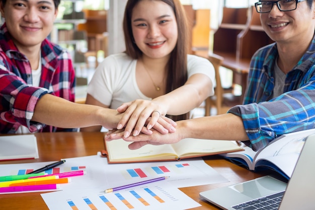 Estudiantes asiáticos felices intercambian ideas para aprender y estudiar estadísticas matemáticas en el aula universitaria