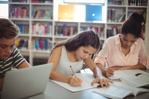 Estudiantes atentos que estudian en la biblioteca