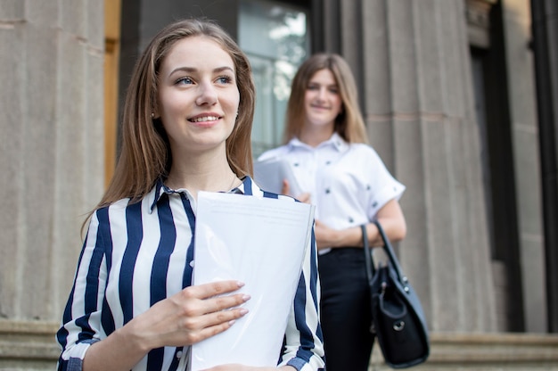 Estudiantes bonitos de pie cerca de la universidad