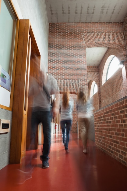 Estudiantes caminando por un pasillo lejos de la cámara