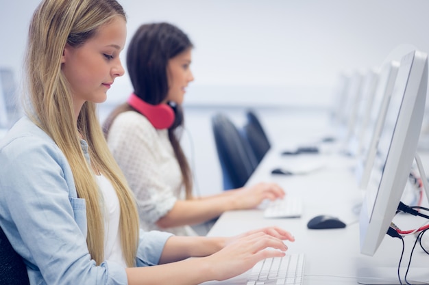 Estudiantes concentrados usando la computadora en la universidad