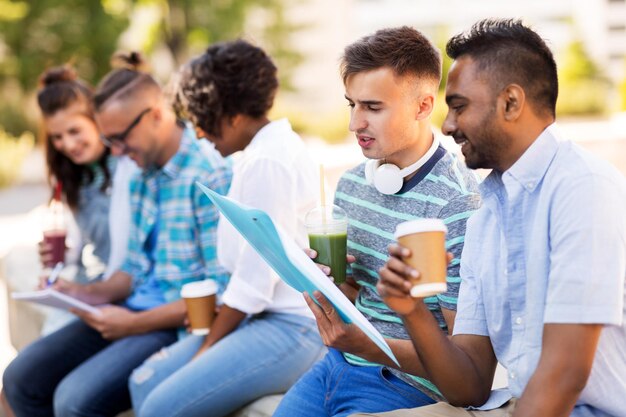 estudiantes con cuadernos y bebidas para llevar