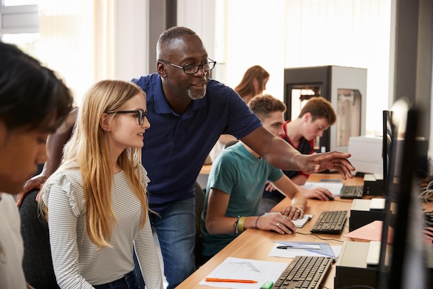 Estudiantes de diseño con profesor trabajando en un laboratorio de impresión CAD3D