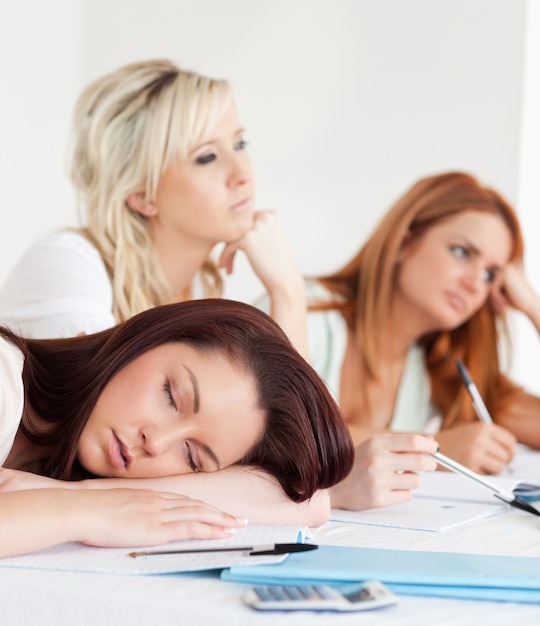 Estudiantes una durmiendo sentado en una mesa