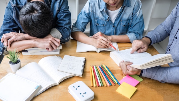 Los estudiantes de la escuela secundaria o los compañeros de clase, tutor en la biblioteca, estudian y leen con ayuda, ayudan a un amigo a hacer la tarea