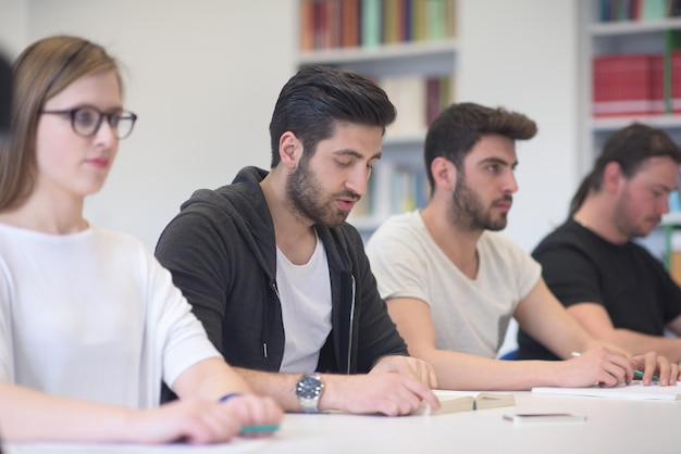 los estudiantes estudian en grupo juntos en el aula de la escuela y trabajan juntos en el proyecto de tarea