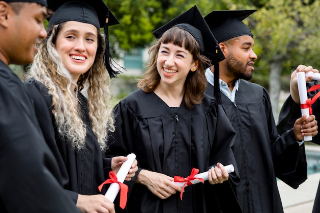 Estudiantes felices graduándose de la universidad, celebrando con diplomas