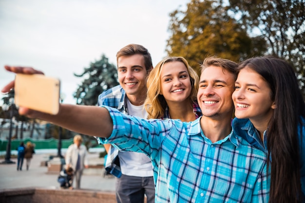 Foto estudiantes felices tomando selfie en el parque juntos