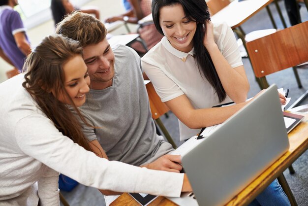 Foto estudiantes en grupo y trabajando juntos en la computadora portátil en la clase asignación y proyecto en línea en la universidad jóvenes felices y colaboración en la universidad por computadora y blog para investigación académica