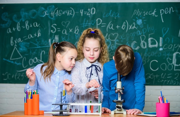 Estudiantes haciendo experimentos de biología con microscopio Niños pequeños aprendiendo química en el laboratorio de la escuela Microscopio de química Niños pequeños en el laboratorio Día de los niños con microscopio de laboratorio Elección difícil