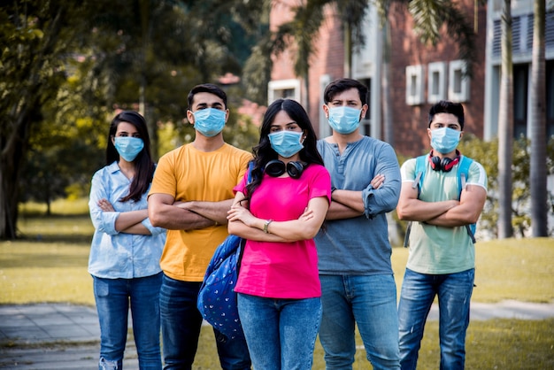 Los estudiantes indios asiáticos usan mascarilla y siguen las normas de distanciamiento social en el campus de la universidad después del desbloqueo de la pandemia de corona, concéntrese en un estudiante