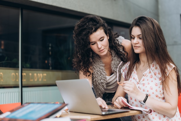 Foto estudiantes inteligentes. dos muchachas están trabajando con la computadora portátil