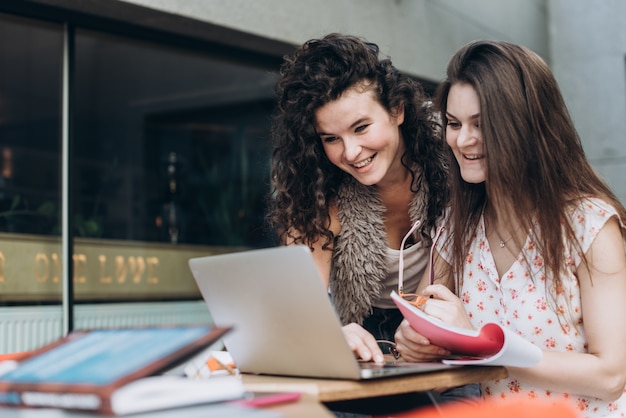 Estudiantes inteligentes. Dos muchachas están trabajando con la computadora portátil