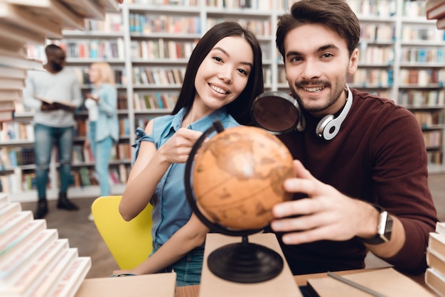 Foto los estudiantes inteligentes están usando el mundo en la biblioteca.