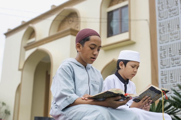 Foto los estudiantes del internado islámico están leyendo el corán en el patio de la mezquita.