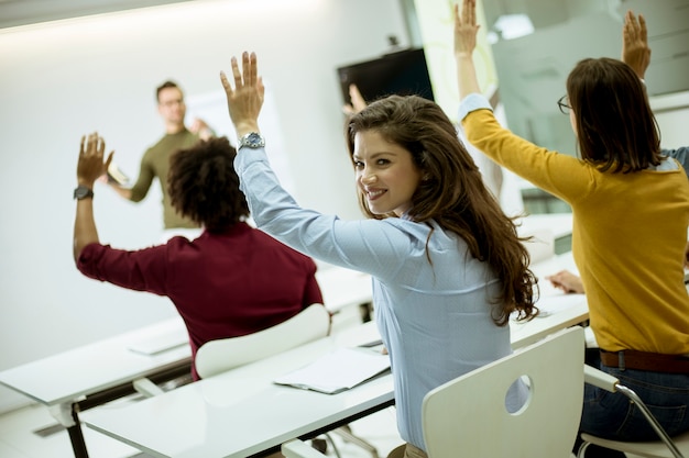 Foto estudiantes levantando la mano para responder a la pregunta durante el taller de capacitación.