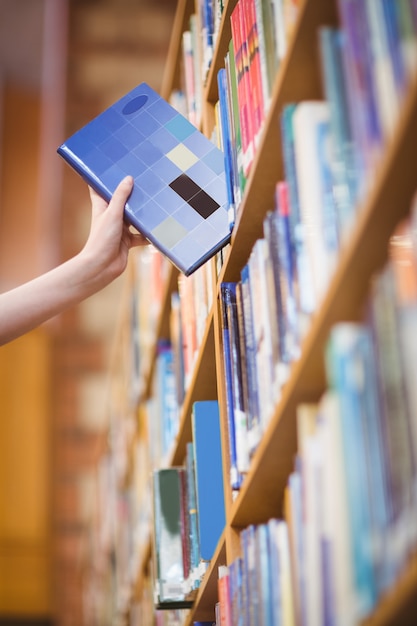 Foto los estudiantes de la mano con el libro de recogida de smartwatch de la estantería