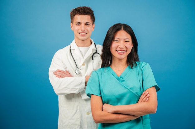 Foto estudiantes de medicina dos médicos adultos jóvenes sonriendo y mirando a la cámara para ver un diagnóstico en azul