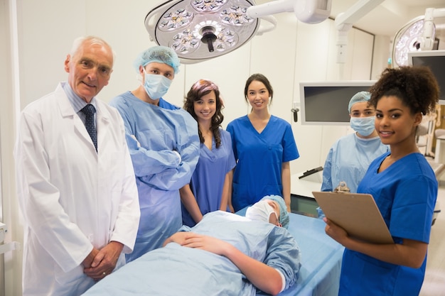 Estudiantes de medicina y profesor sonriendo a la cámara