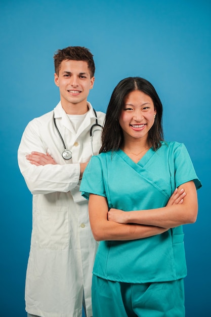 Estudiantes de medicina verticales dos médicos adultos jóvenes sonriendo y mirando a la cámara para ver un