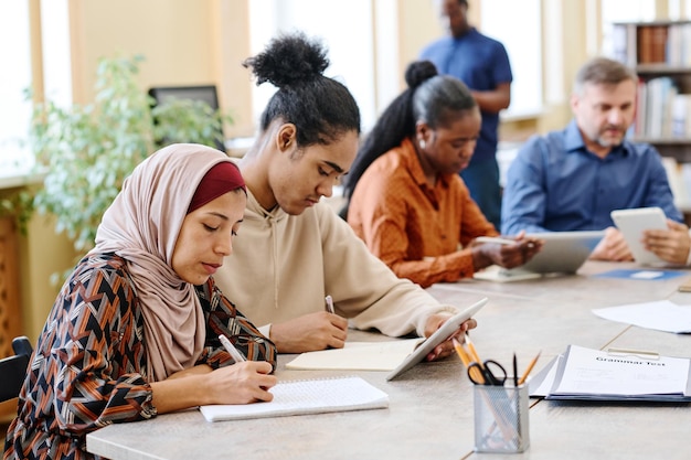 Estudiantes migrantes haciendo tareas de escritura.