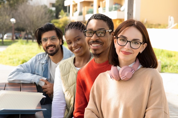 Estudiantes milenarios positivos y diversos en el estudio causal y preparan proyectos o prueban juntos en la mesa