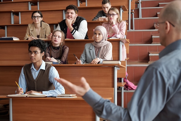 Los estudiantes mirando la pizarra mientras el profesor explica algo en la lección