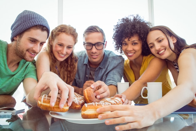 Foto estudiantes de moda comiendo donas