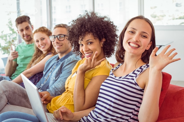 Estudiantes de moda sonriendo y saludando a la cámara