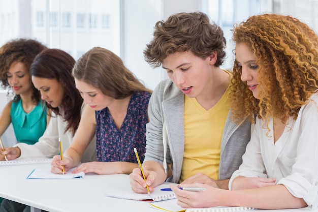 Estudiantes de moda tomando notas en clase