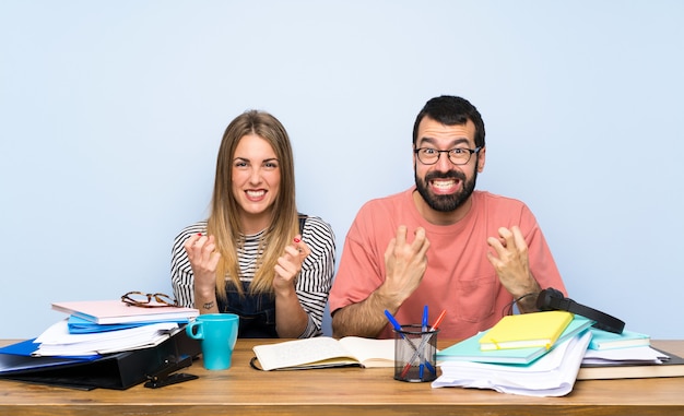 Estudiantes con muchos libros frustrados por una mala situación.