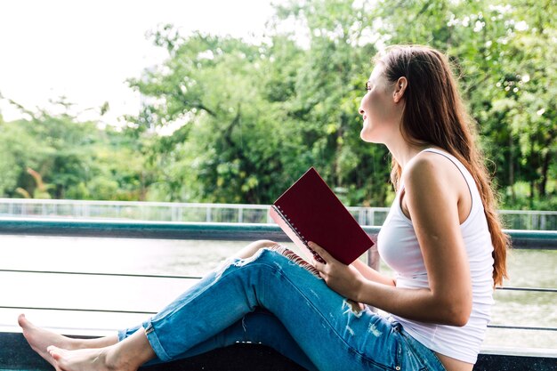 Estudiantes de mujer leyendo portátiles al aire libre