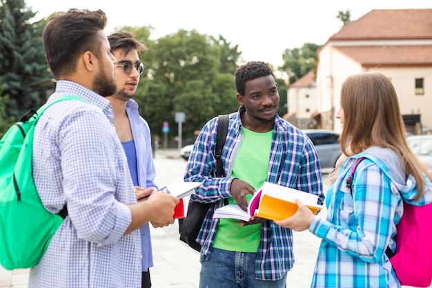 Los estudiantes multinacionales hablan entre ellos sobre libros.