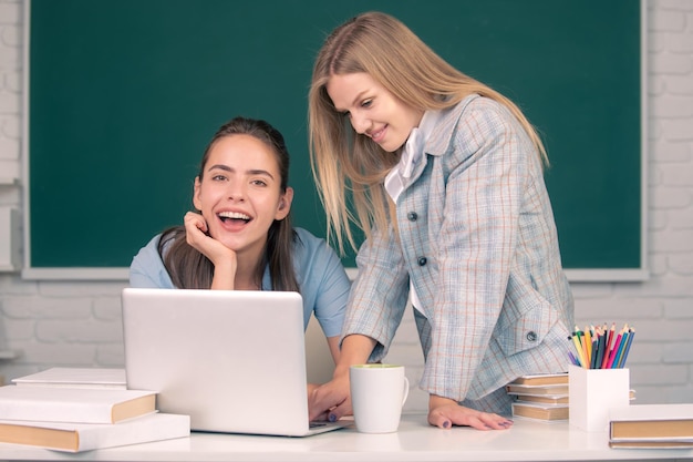 Estudiantes niñas en el aula en la universidad Dos estudiantes haciendo la tarea juntos y ayudándose unos a otros