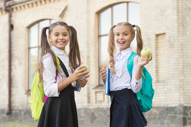 Estudiantes niñas compañeros de clase con mochilas con almuerzo escolar, concepto de comida de desayuno.