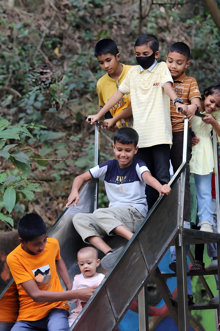 Estudiantes no identificados de Bd juegan a la diapositiva en Chittagong, Bangladesh