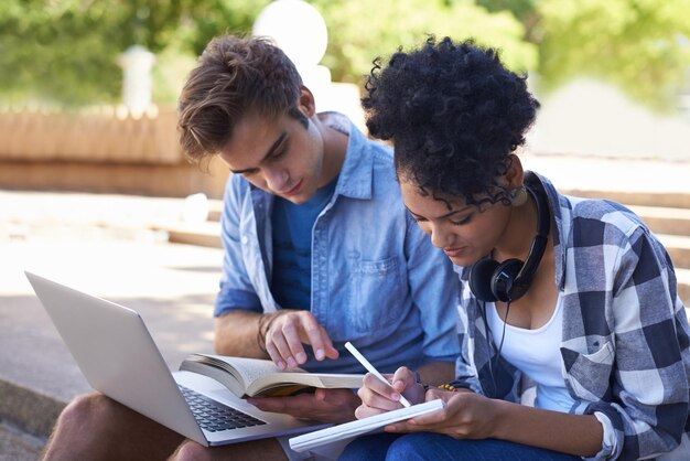 Estudiantes portátiles y trabajo en equipo en el campus para educación o proyecto en línea investigación o estudio Hombre mujer y portátil para la universidad libro en el parque de jardín para conectividad a Internet universidad o apoyo