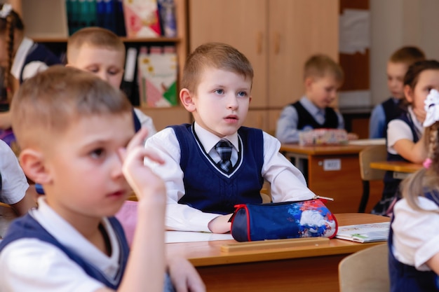 Los estudiantes de primaria en sus escritorios en el aula.