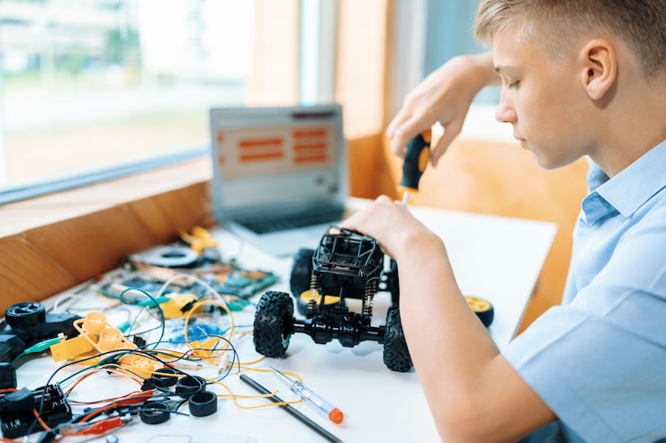 Foto estudiantes que arreglan vehículos robóticos aprenden tecnología en la edificación de la clase del tallo