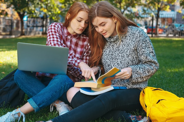 Estudiantes que estudian al aire libre en el campus de la universidad