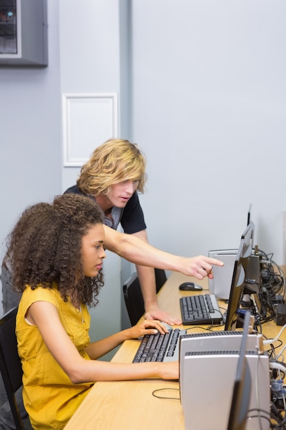 Foto estudiantes que trabajan en la computadora en el aula