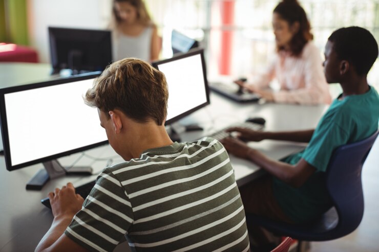 Foto estudiantes que usan la computadora en el aula.