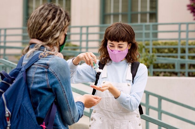 Estudiantes que usan mascarilla en la escuela y usan gel de alcohol en la nueva normalidad.