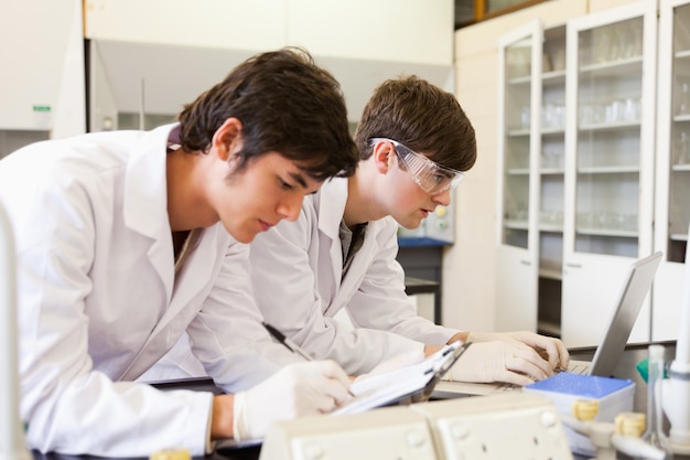 Estudiantes de química escribiendo un informe